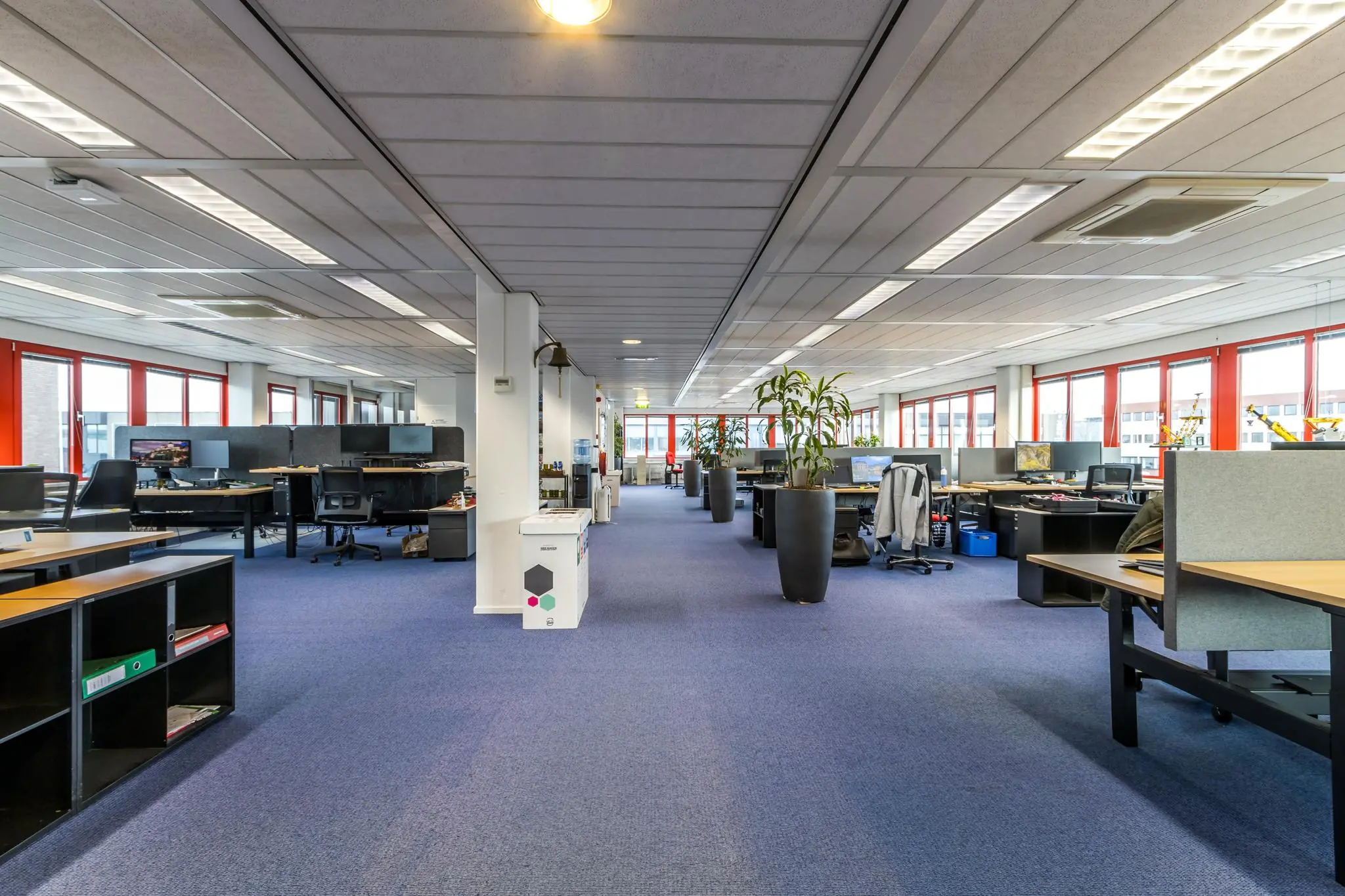 Ruim en modern kantoorinterieur aan de Savannahweg met open werkplekken, bureaus en grote ramen.