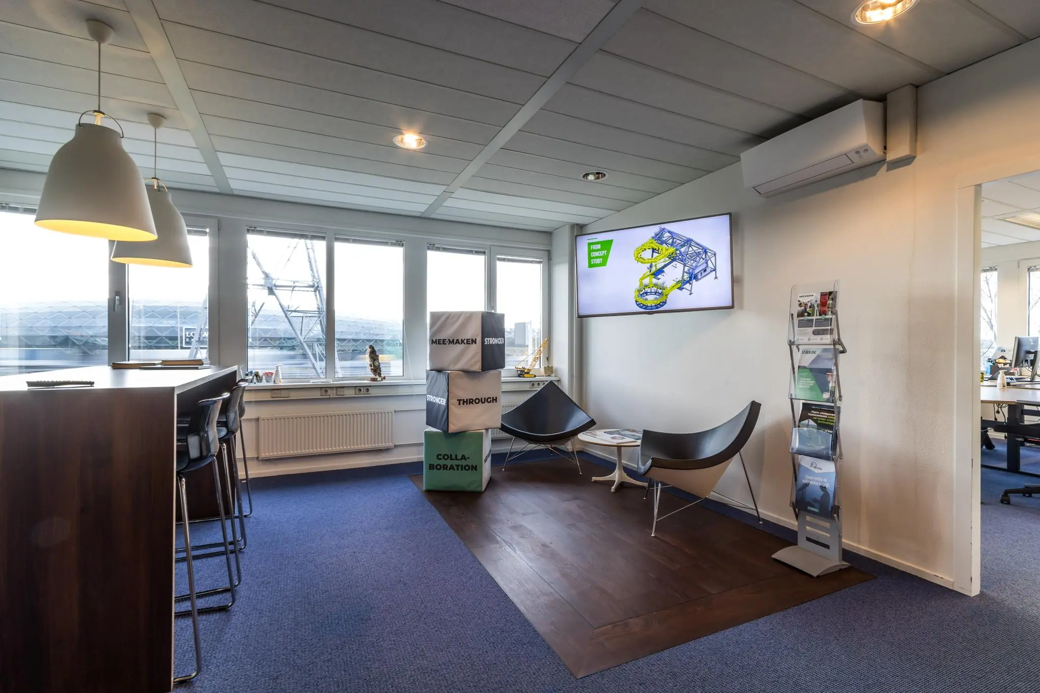 Moderne kantoorruimte aan de Savannahweg met zithoek, hoge tafel, informatiescherm en folders.