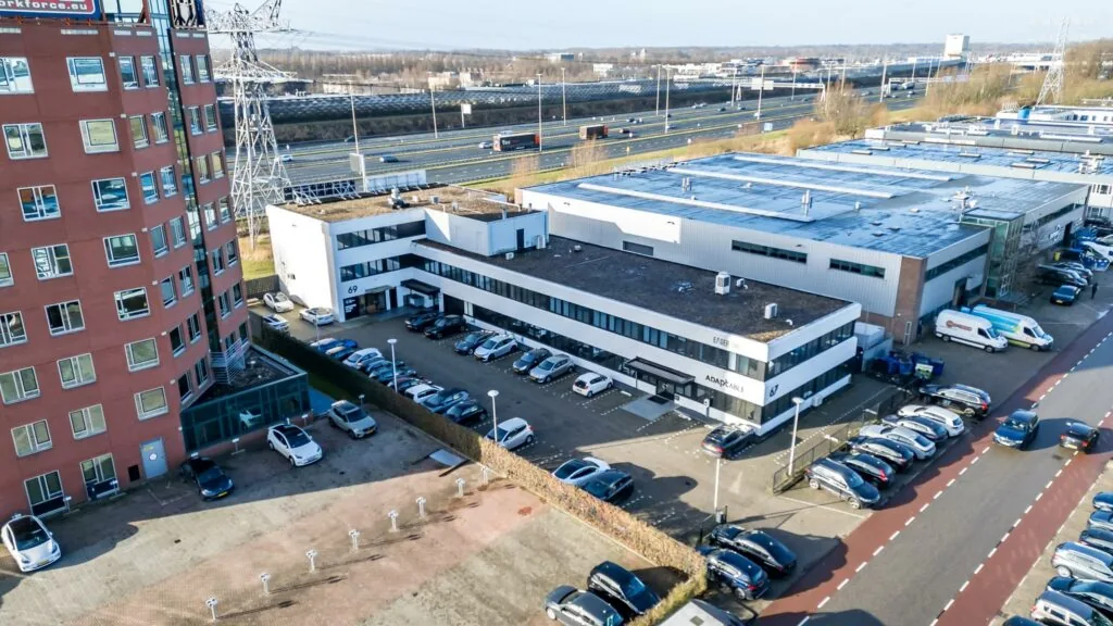 Luchtfoto van een kantoorgebouw aan de Savannahweg in een bedrijventerrein met parkeerplaatsen en nabijgelegen snelweg.