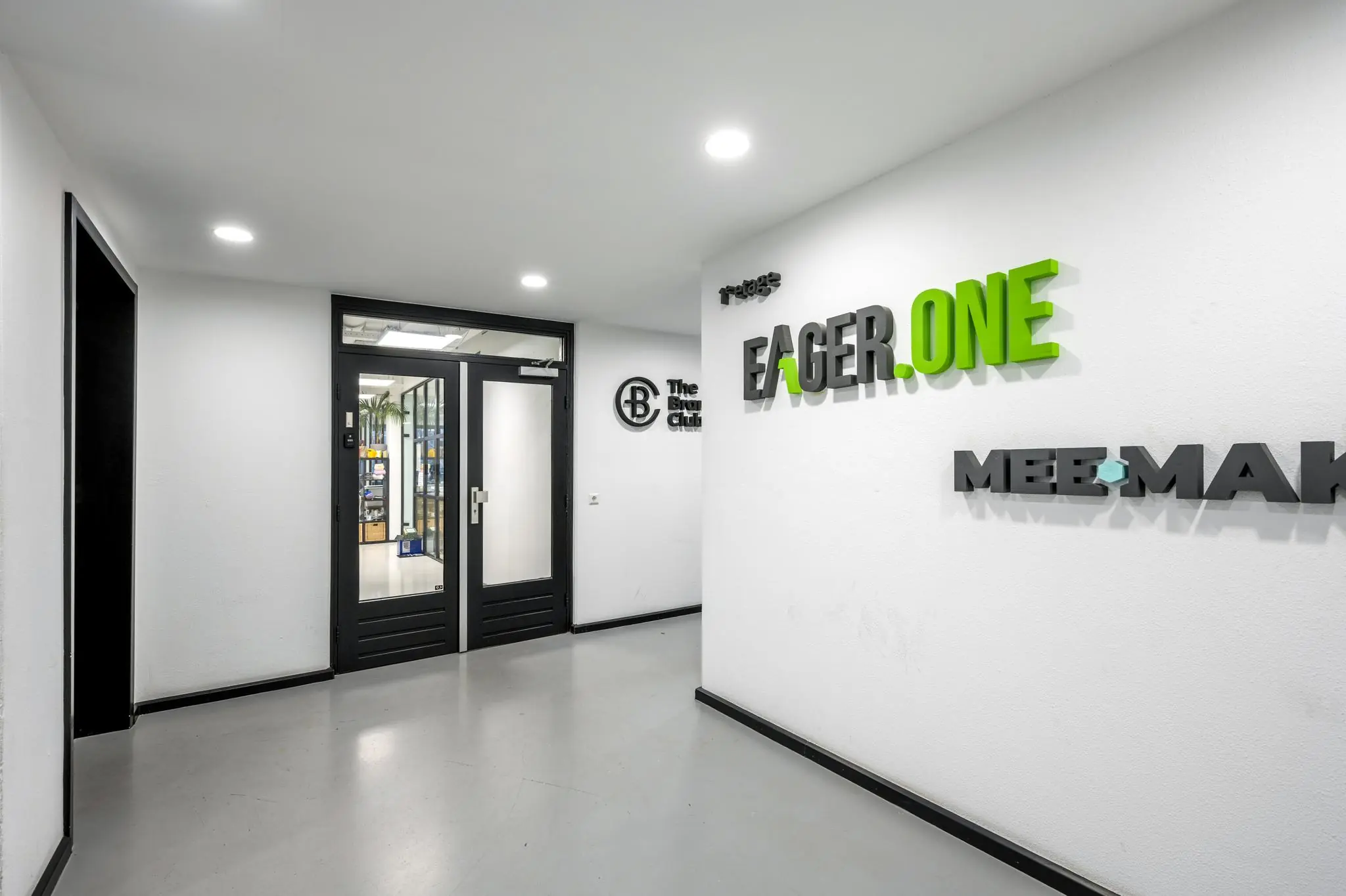 Moderne kantoorhal aan de Savannahweg met bedrijfslogo’s van Eager.One, The Beacon Club en Mee-Maken op de muur.