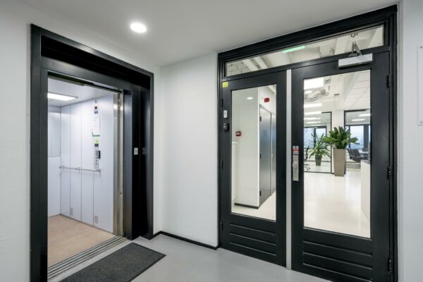 Entreehal met een open lift en glazen deur naar een modern kantoor aan de Savannahweg.