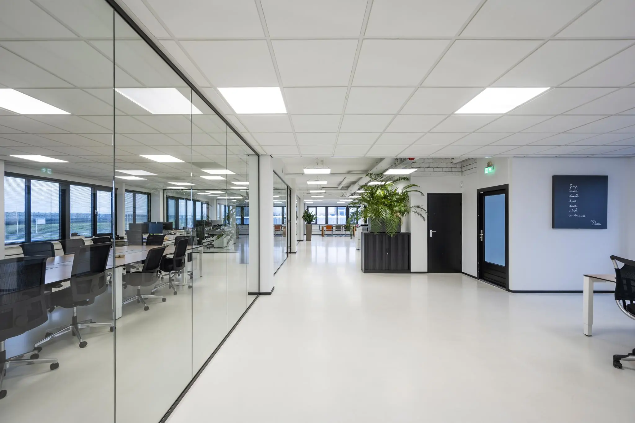 Moderne, lichte kantoorruimte aan de Savannahweg met glazen wanden, bureaus en veel natuurlijk licht.