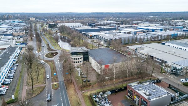 Luchtfoto van bedrijventerrein Koningsweg met kantoren, magazijnen, wegen en een waterpartij in beeld.
