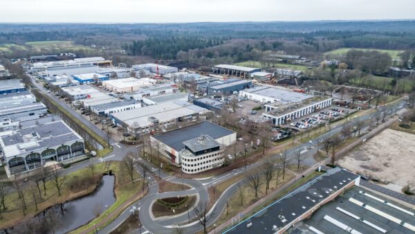 Luchtfoto van het industrieterrein Koningsweg met bedrijfsgebouwen, parkeerplaatsen en omliggend groen.