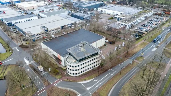 Luchtfoto van een kantoorpand aan de Koningsweg, omringd door bedrijfspanden en wegen in een bedrijventerrein.