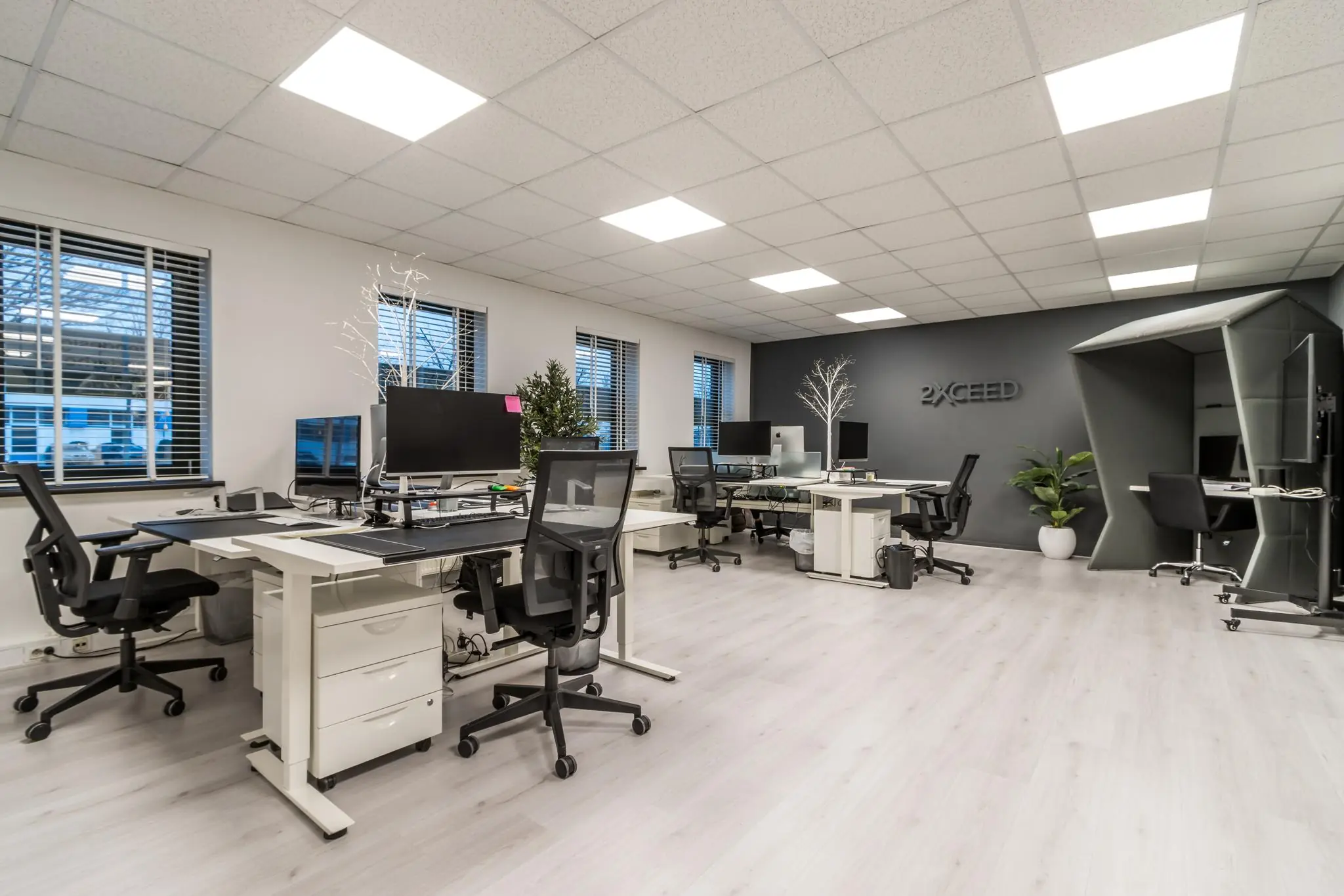 Modern kantoorinterieur aan de Koningsweg met meerdere bureaus, beeldschermen en een stille werkruimte.