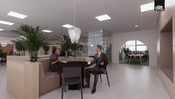 Twee mensen zitten aan een ronde tafel in een modern kantoorinterieur aan de Spicalaan, ingericht met planten en glazen vergaderruimtes.