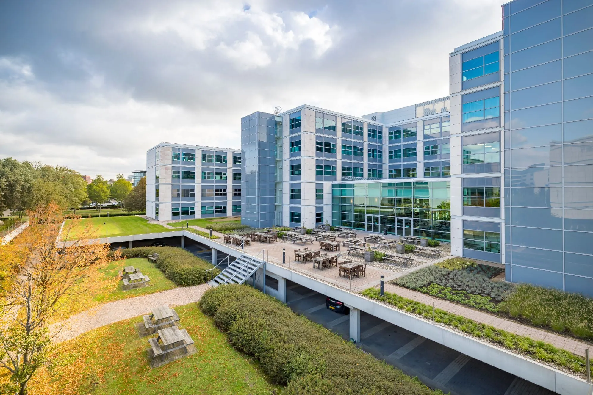 Modern kantoorgebouw aan de Spicalaan met een ruim terras, groene tuin en picknicktafels.