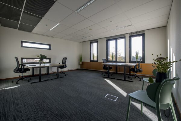 Modern en licht kantoor aan de Fokkerstraat met meerdere werkplekken en grote ramen.