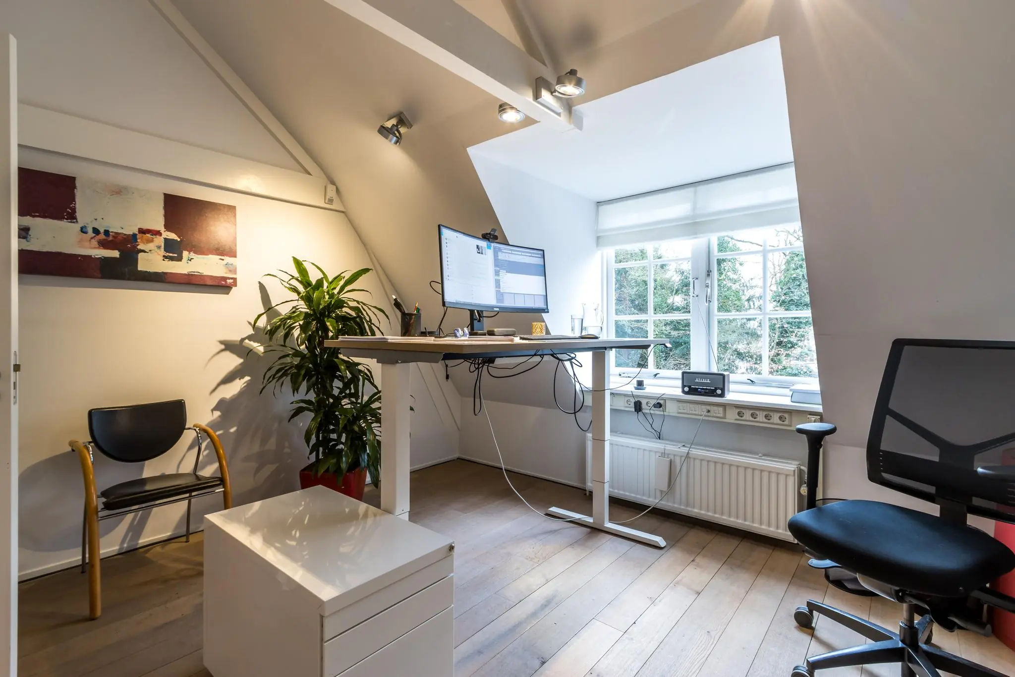 Modern thuiskantoor aan de Driebergseweg met een zit-sta bureau, groot beeldscherm en veel daglicht.
