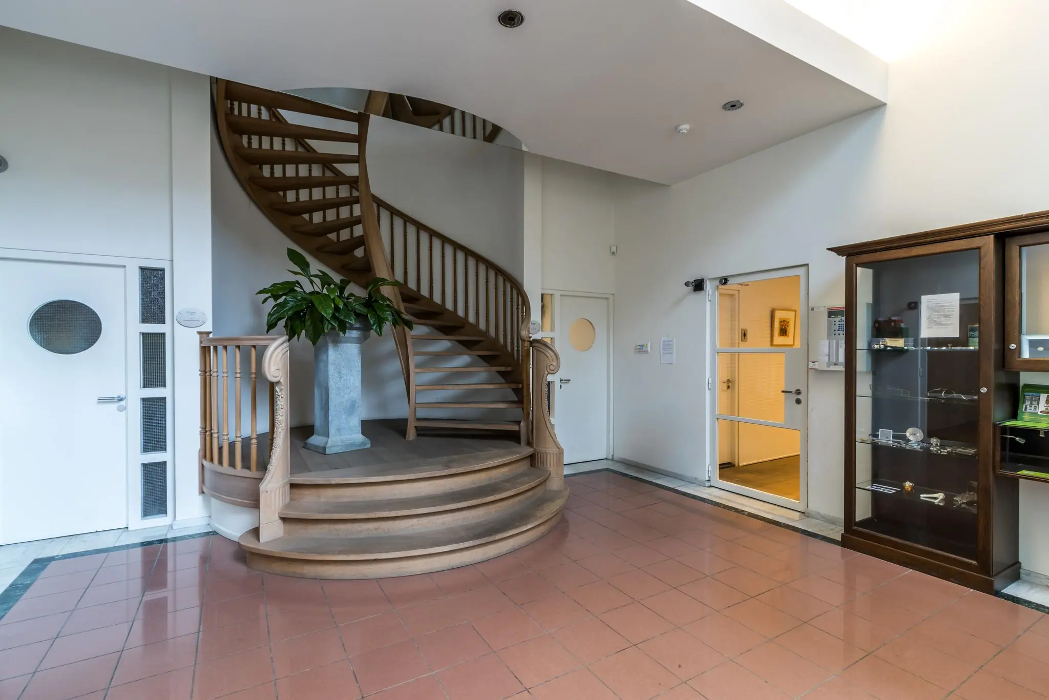 Halfronde houten trap in een ruime en lichte entreehal aan de Driebergseweg.