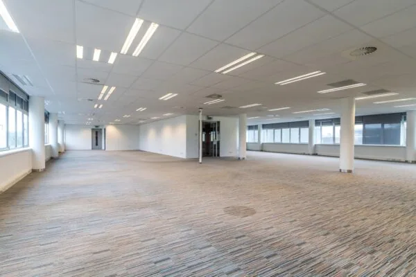 Lichte, lege kantoorruimte aan de Lemelerbergweg met grote ramen en systeemplafond.