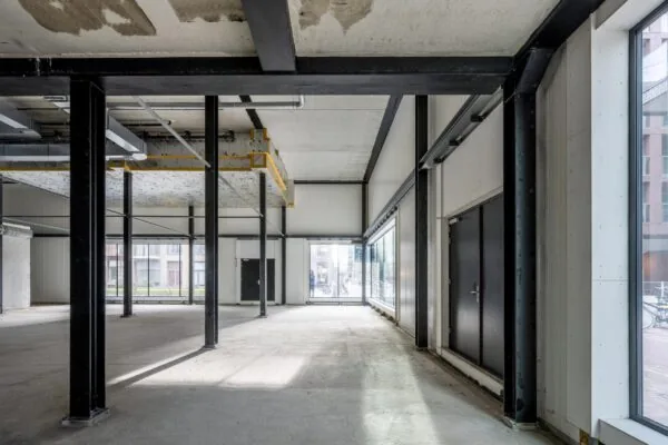 Leeg commercieel casco hoekpand aan de Pieter Goosstraat met zichtbare staalconstructie en grote raampartijen.