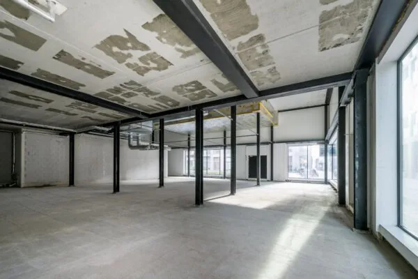 Leegstaand commercieel pand aan de Pieter Goosstraat met betonnen vloer, staalconstructie en grote raampartijen.