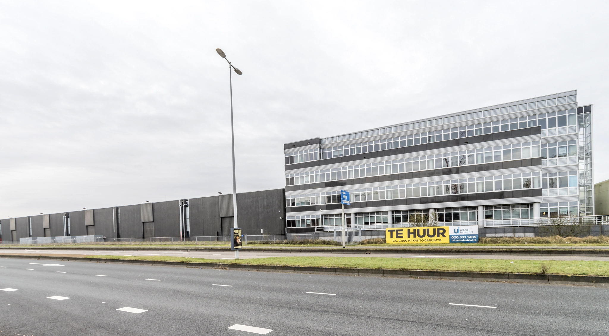 Kantoorgebouw aan de Lemelerbergweg met bord "Te Huur" voor circa 2.000 m² kantoorruimte.