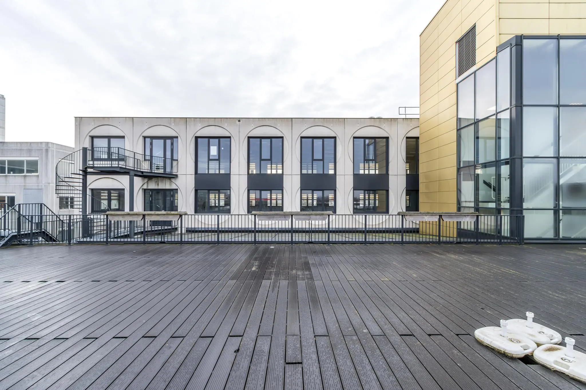 Dakterras met houten vlonders en uitzicht op een modern kantoorgebouw aan de Laarderhoogtweg.