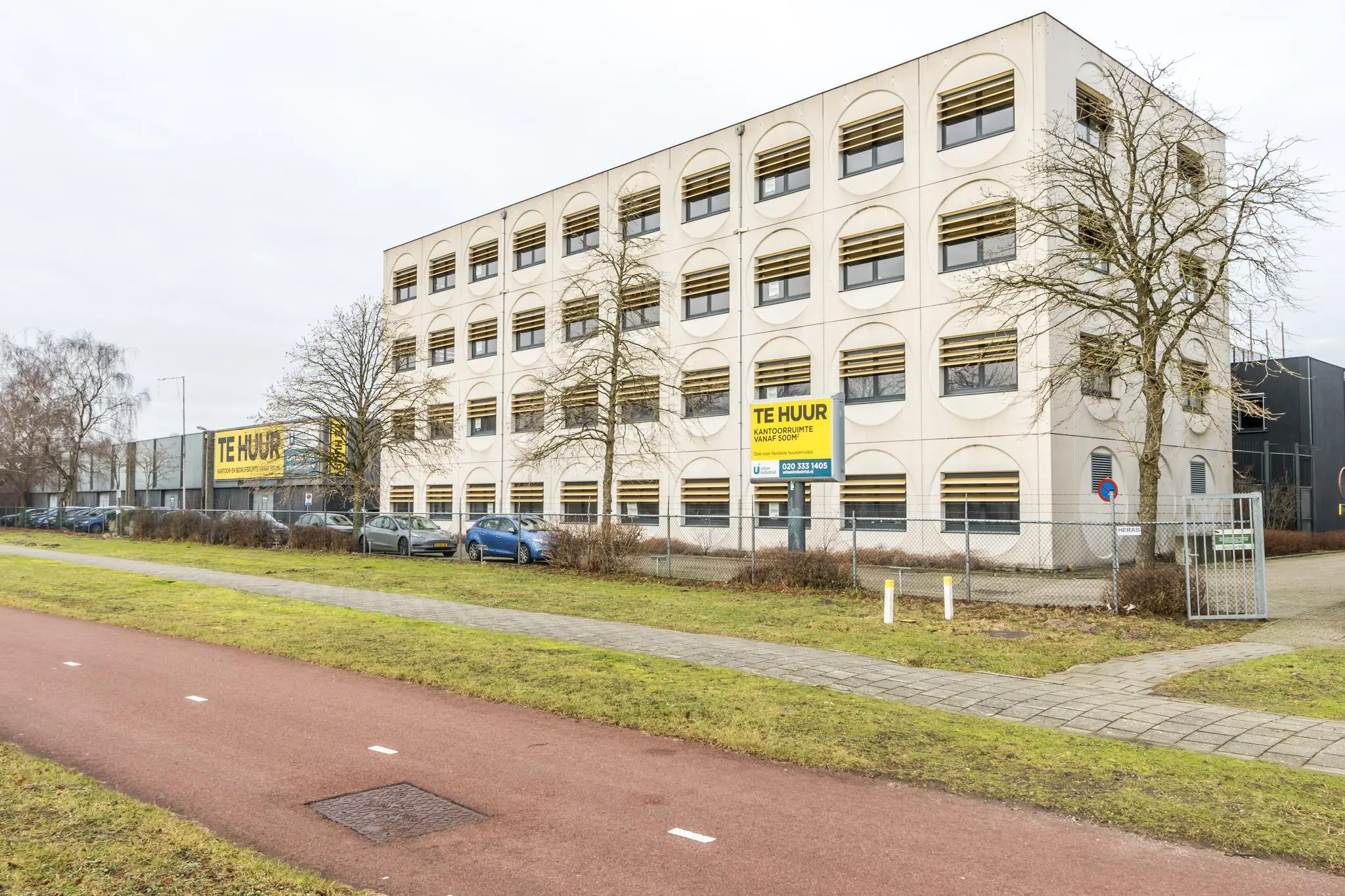 Kantoorgebouw aan de Laarderhoogtweg in Amsterdam met meerdere "Te Huur" borden zichtbaar.