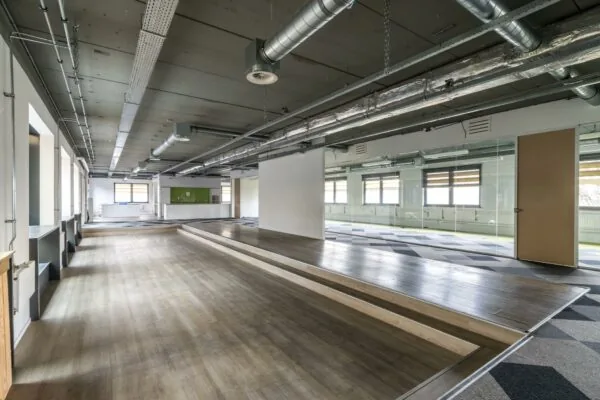 Moderne, industriële kantoorruimte aan de Laarderhoogtweg met open indeling, verhoogd vloerplatform en zichtbare luchtkanalen.