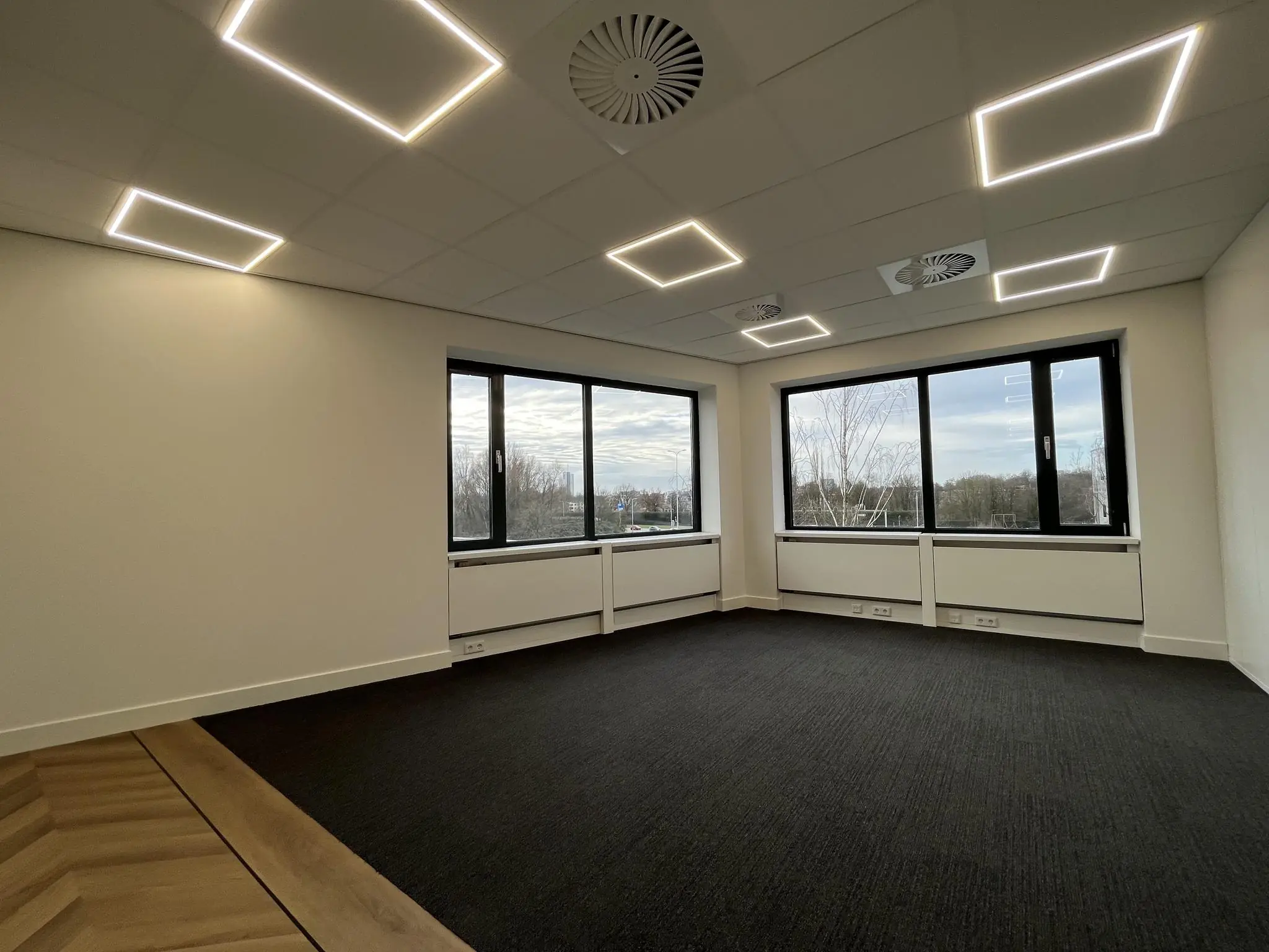 Licht en modern kantoorpand aan de Euclideslaan met grote ramen en LED-verlichting in het plafond.