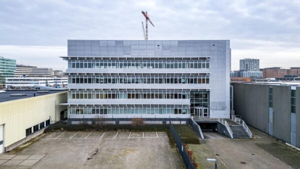 Kantoorgebouw aan de Lemelerbergweg met glazen gevel en aangrenzende parkeerplaats in Amsterdam Zuidoost.