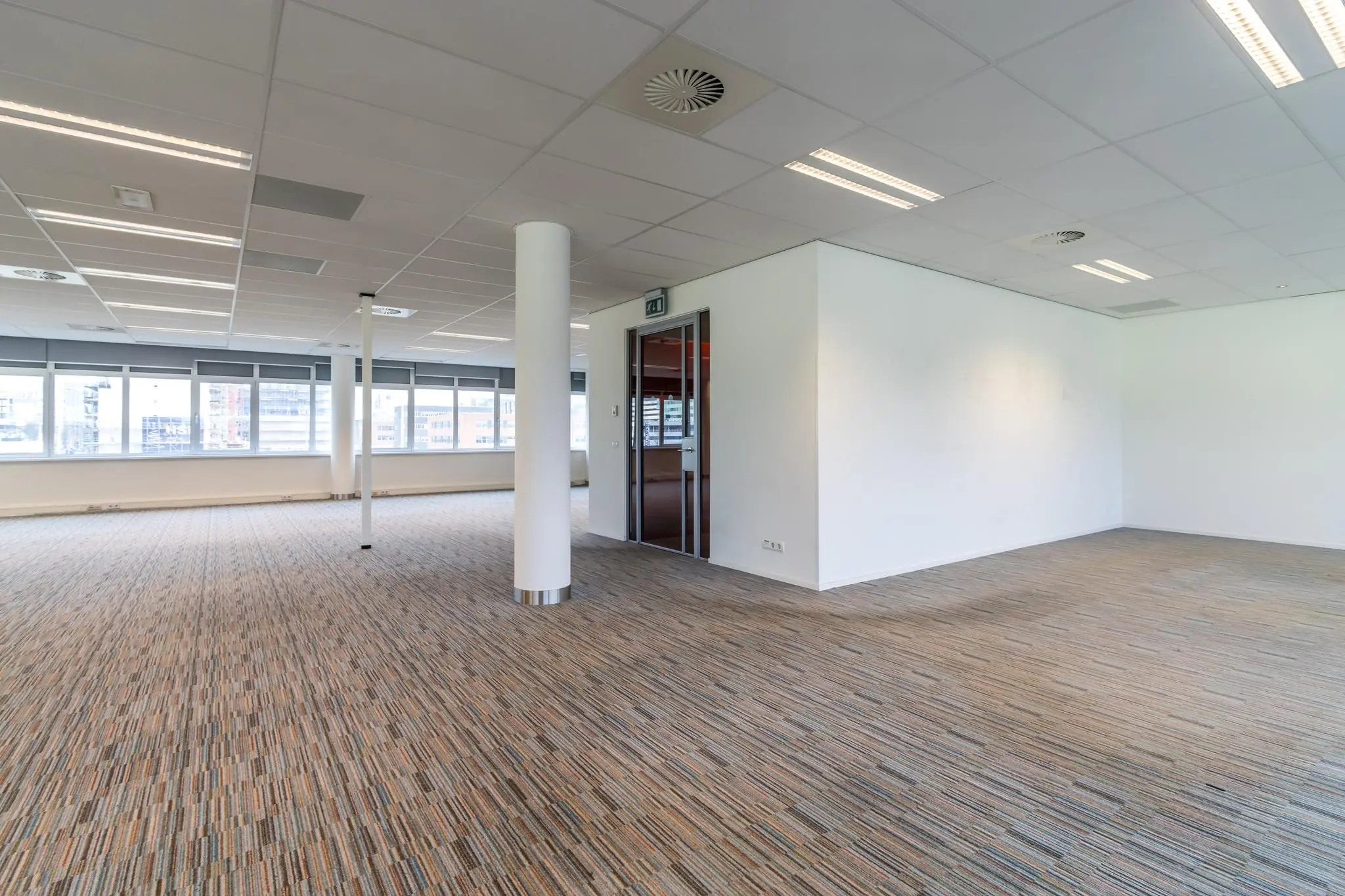 Leeg, modern kantoorruimte aan de Lemelerbergweg met grote ramen en systeemplafond.