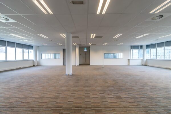 Leeg kantoorinterieur aan de Lemelerbergweg met tapijtvloer, systeemplafond en grote ramen.