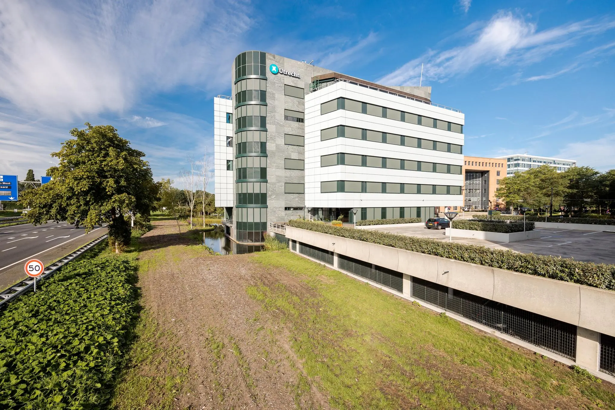 Kantoorgebouw aan de Euclideslaan in Utrecht, gelegen naast een snelweg en voorzien van parkeergelegenheid.