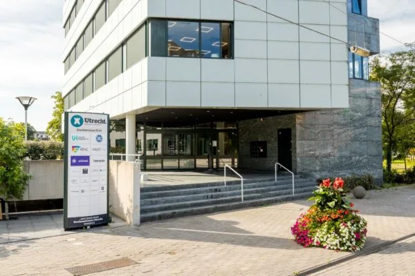 Ingang van een modern kantoorgebouw aan de Euclideslaan in Utrecht met bedrijfsbord en bloembak op de voorgrond.