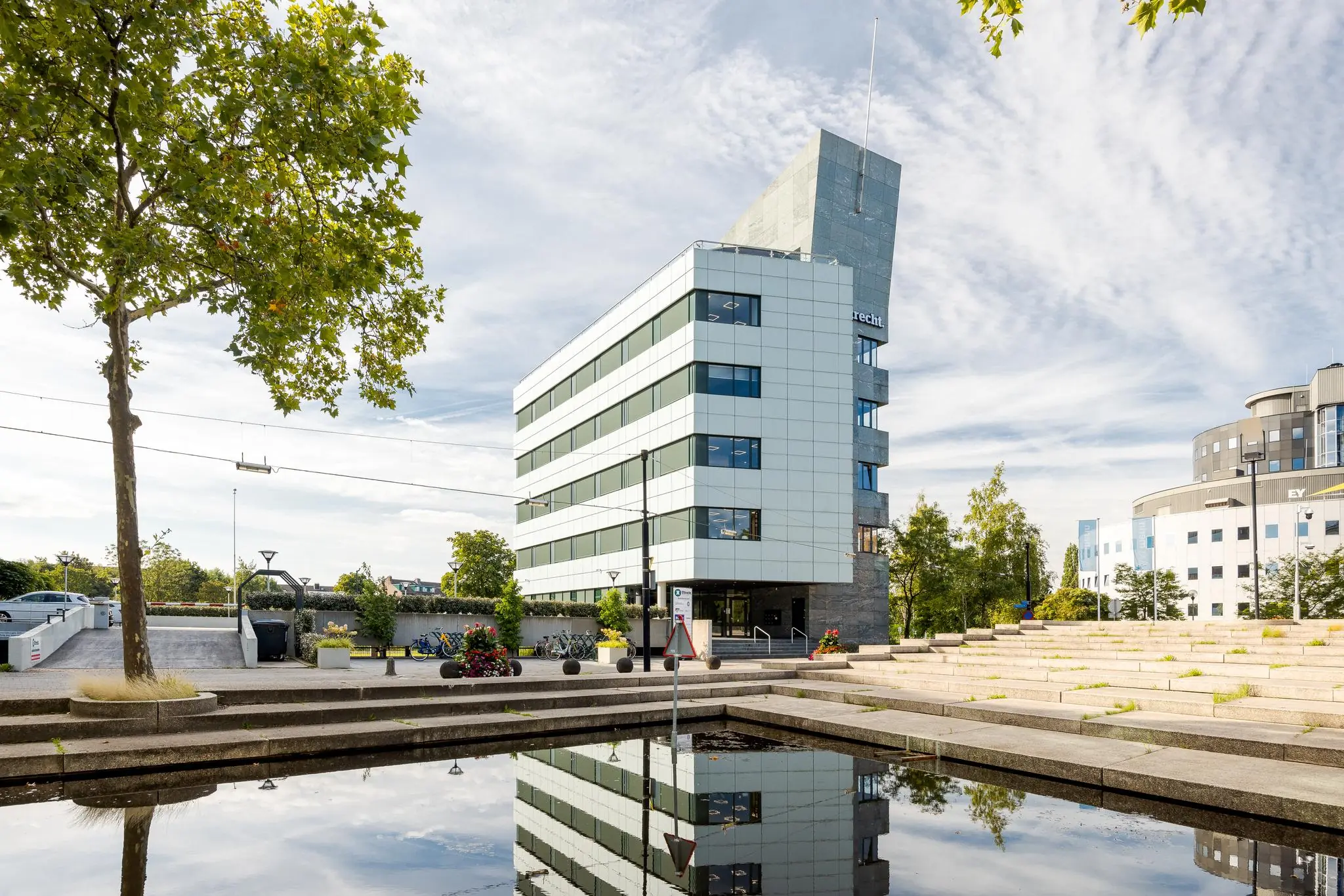 Modern kantoorgebouw aan de Euclideslaan in Utrecht met vijver en trappen in de voorgrond.