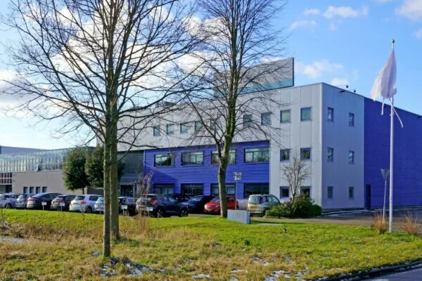 Modern kantoorgebouw aan de Zuiderweg met geparkeerde auto's op de voorgrond.