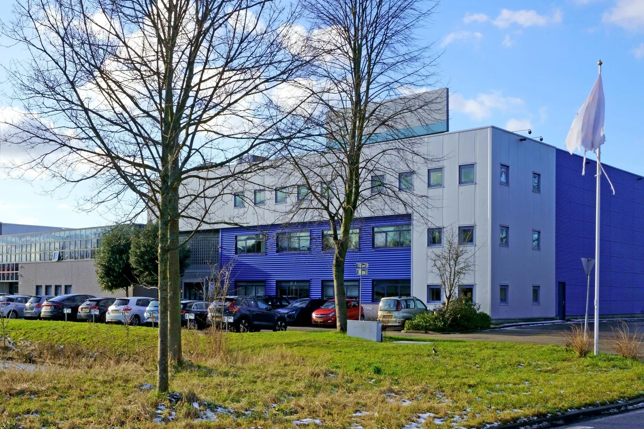 Modern kantoorgebouw aan de Zuiderweg met geparkeerde auto's op de voorgrond.