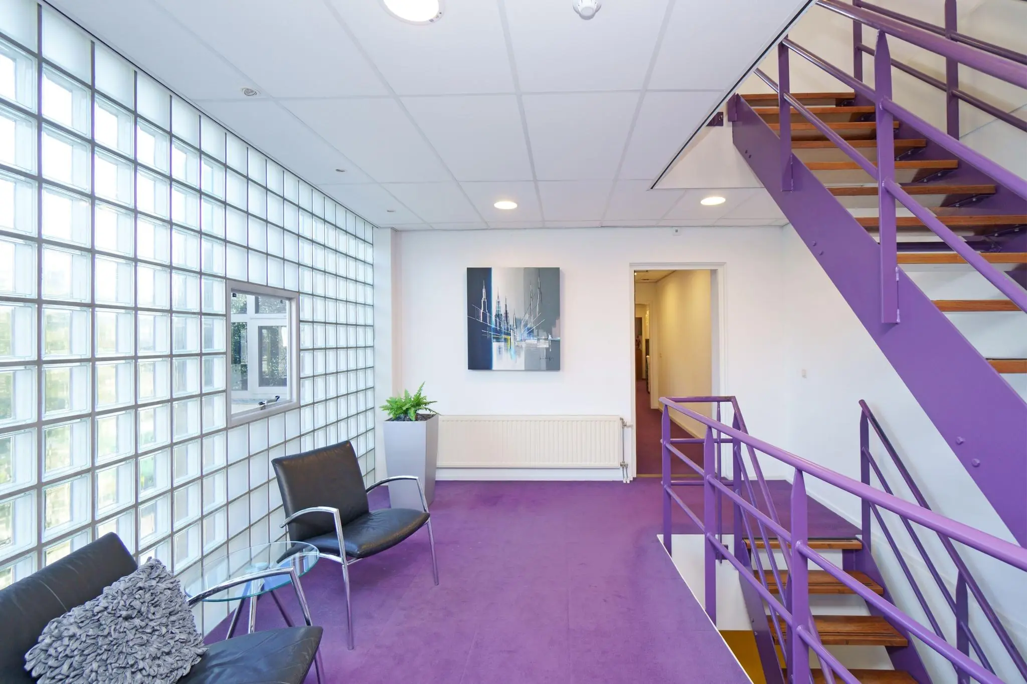 Moderne paarse overloop met glazen wand, zwarte stoelen, een schilderij en een stalen trap.