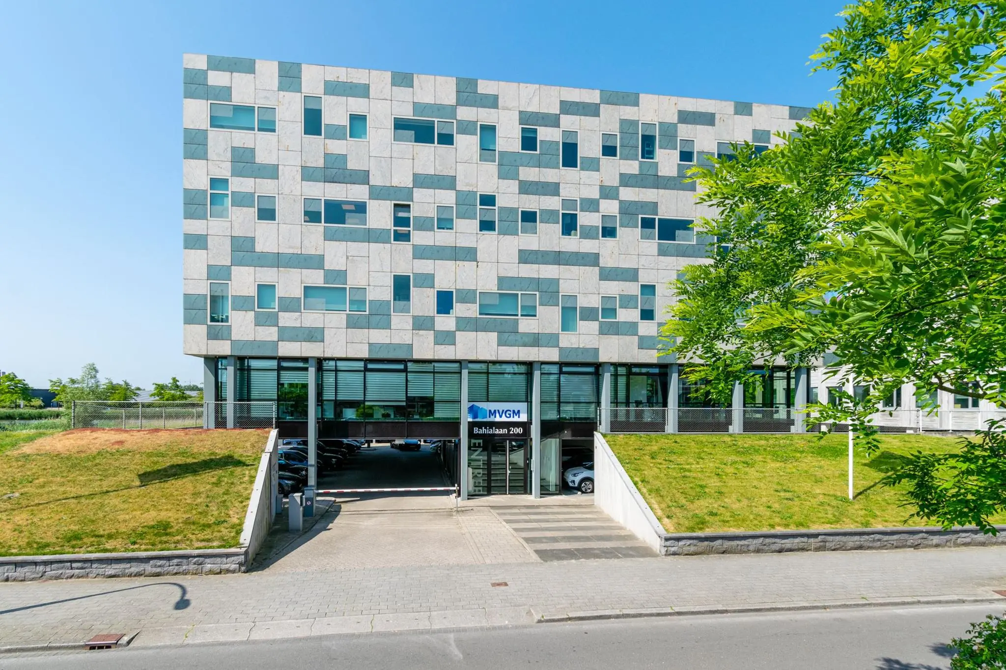 Modern kantoorgebouw aan de Bahialaan 200 met opvallende gevel en MVGM-naam bij de ingang.