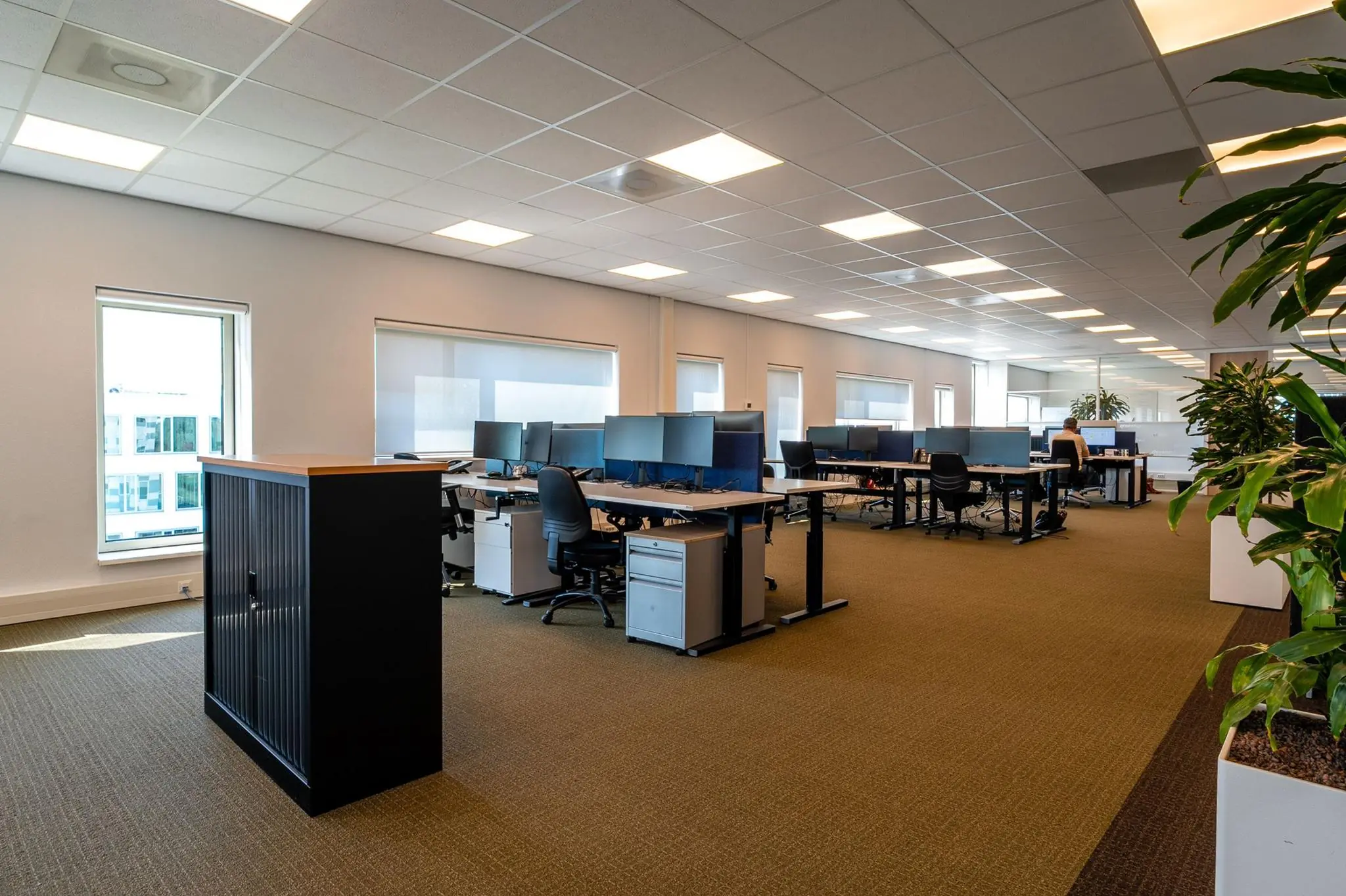 Modern en ruim kantoorinterieur aan de Bahialaan met meerdere werkplekken en grote ramen.