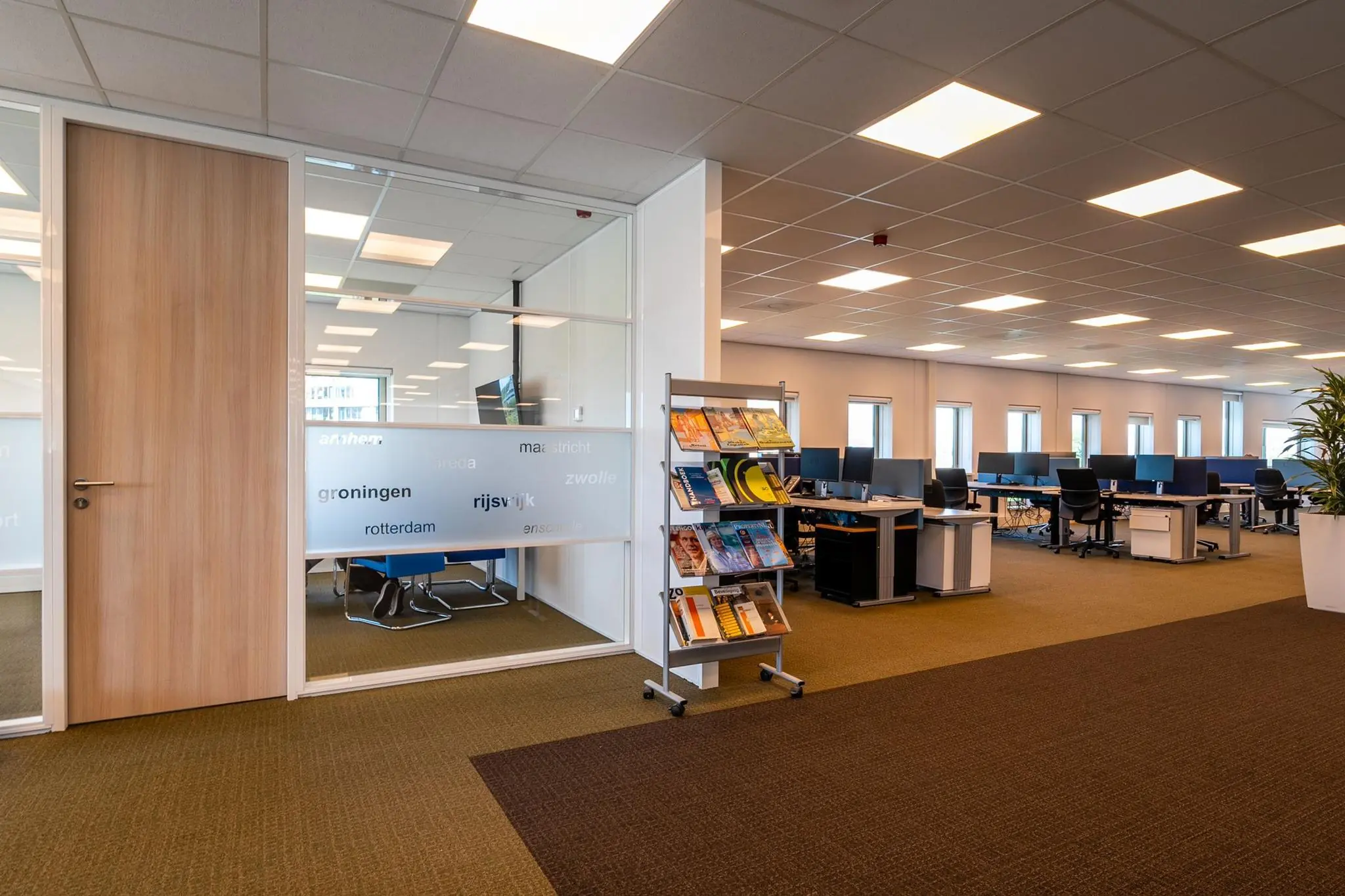 Moderne kantooruimte aan de Bahialaan met werkplekken, vergaderruimte en tijdschriftenrek.