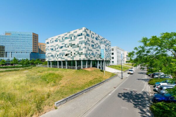 Modern kantoorgebouw aan de Bahialaan in Rotterdam met omliggend groen en parkeerplaatsen op een zonnige dag.