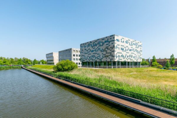 Modern kantoorgebouw aan de Bahialaan in Rotterdam, gelegen naast een waterpartij en omgeven door groen.