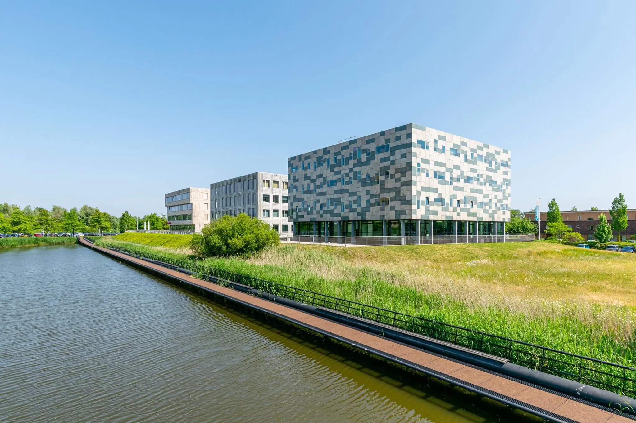 Modern kantoorgebouw aan de Bahialaan in Rotterdam, gelegen naast een waterpartij en omgeven door groen.