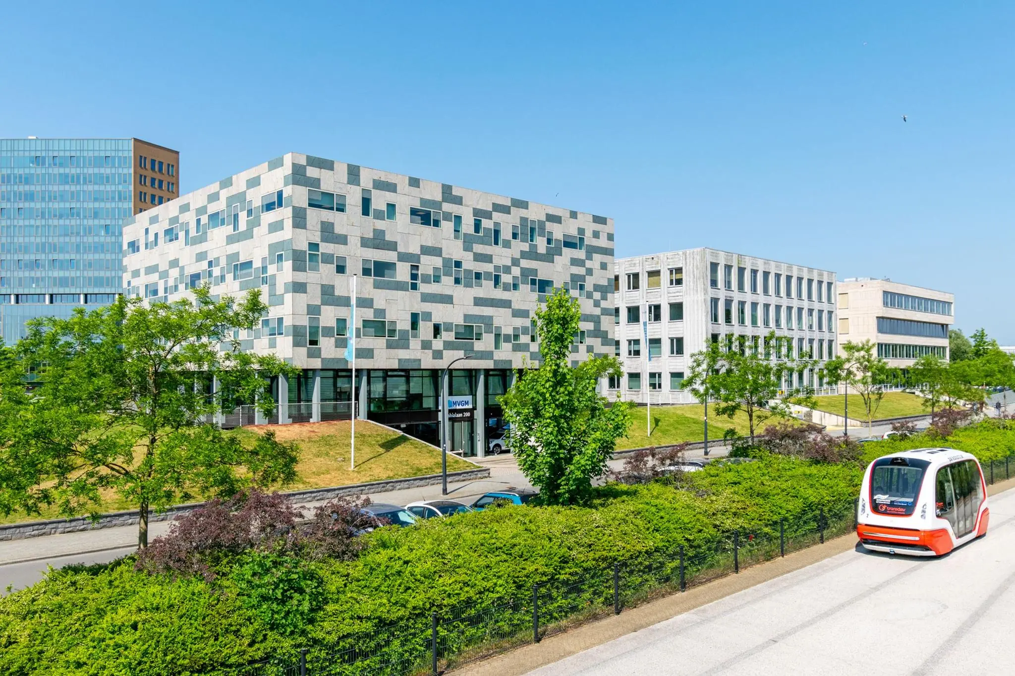 Moderne kantoorgebouwen aan de Bahialaan in Rotterdam met een zelfrijdend voertuig op de voorgrond.