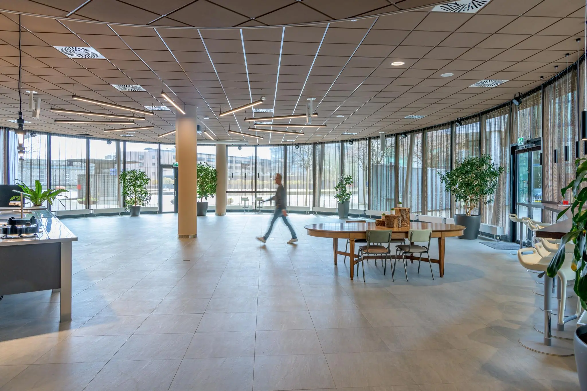 Moderne en ruime lobby op het Enthovenplein met veel daglicht, planten en zitgelegenheid.