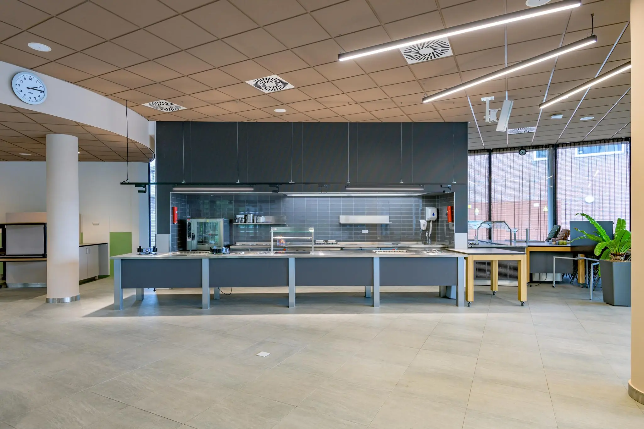 Moderne bedrijfskantine op het Enthovenplein met een strak ingericht uitgiftebuffet en open keuken.