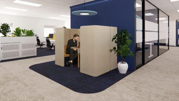 Man werkt op laptop in een afgeschermde zitplek in modern kantoor aan de Kleveringweg.