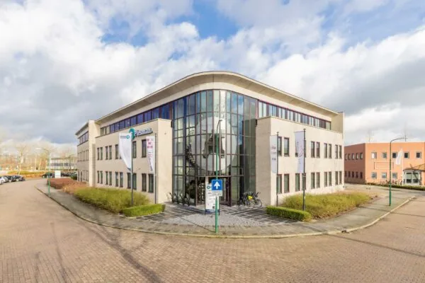 Modern kantoorgebouw aan de Plesmanstraat met glazen entree en vlaggenmast.