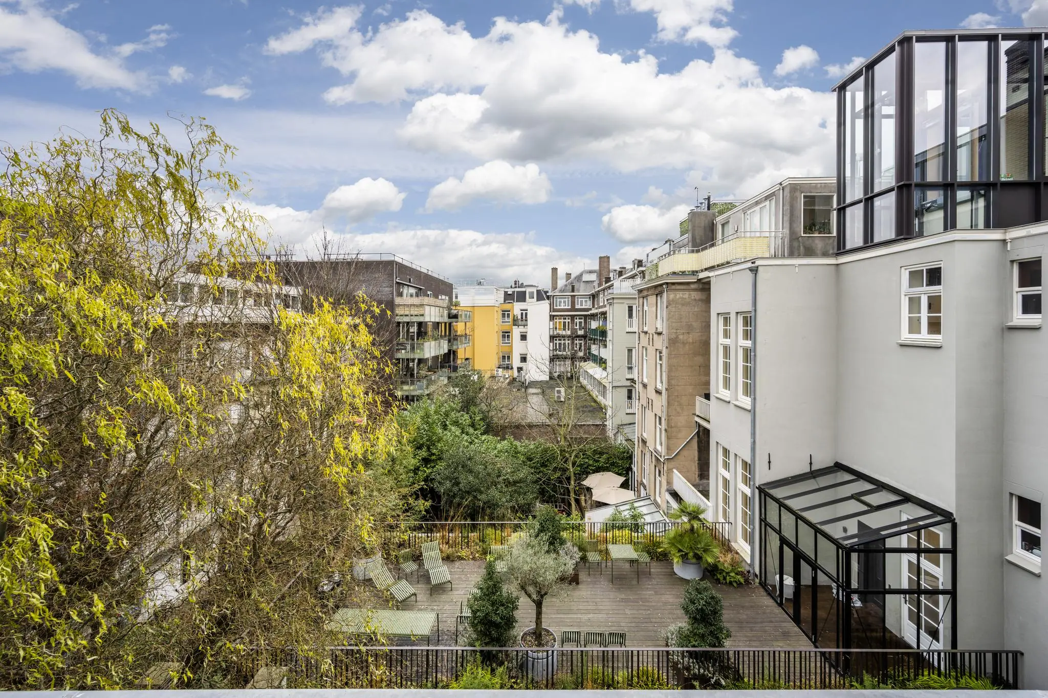 Uitzicht op een binnentuin met terras en omliggende appartementen aan de Overtoom in Amsterdam.