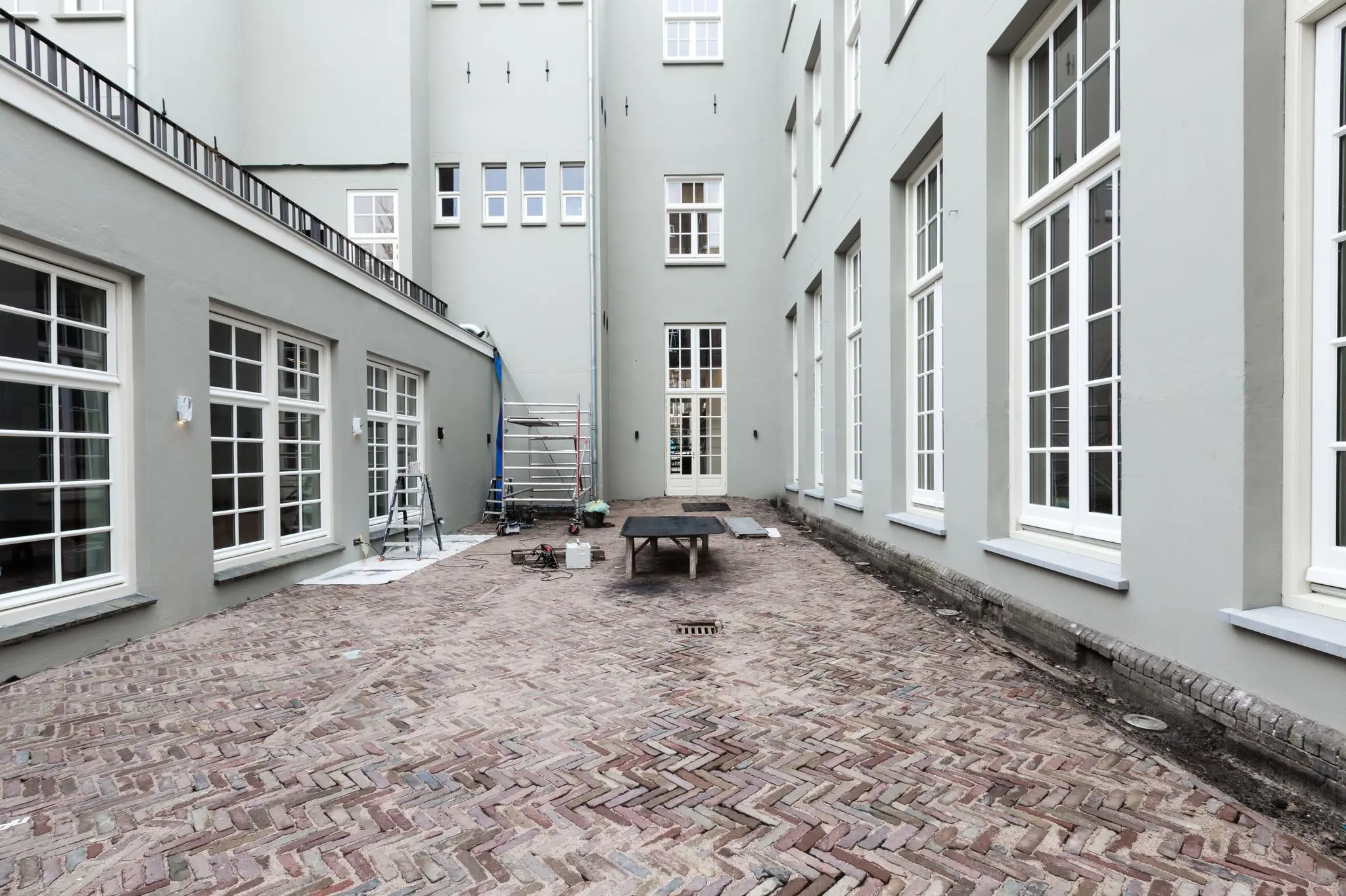 Binnenplaats van een gerenoveerd pand aan de Overtoom met nieuwe bakstenen bestrating en bouwmaterialen.