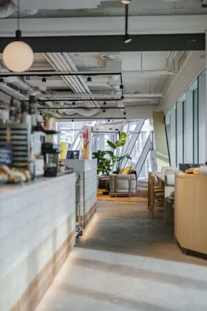 Modern interieur van een koffiebar of lobby aan de Schenkkade met zitgedeelte, planten en veel daglicht.