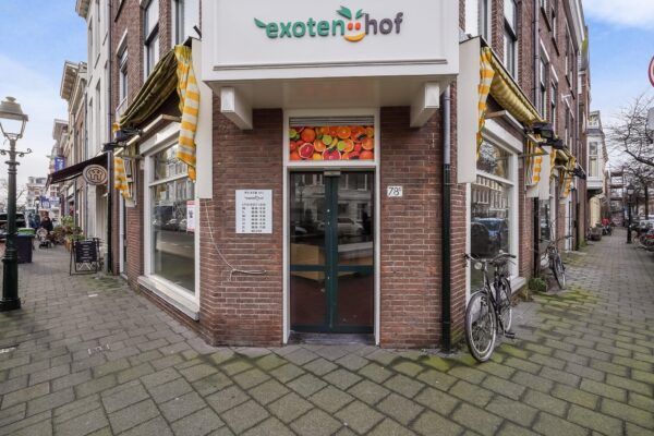 Voorgevel van winkel 'Exotenhof' aan de Bankastraat met uithangbord, etalageramen en fietsen op de stoep.