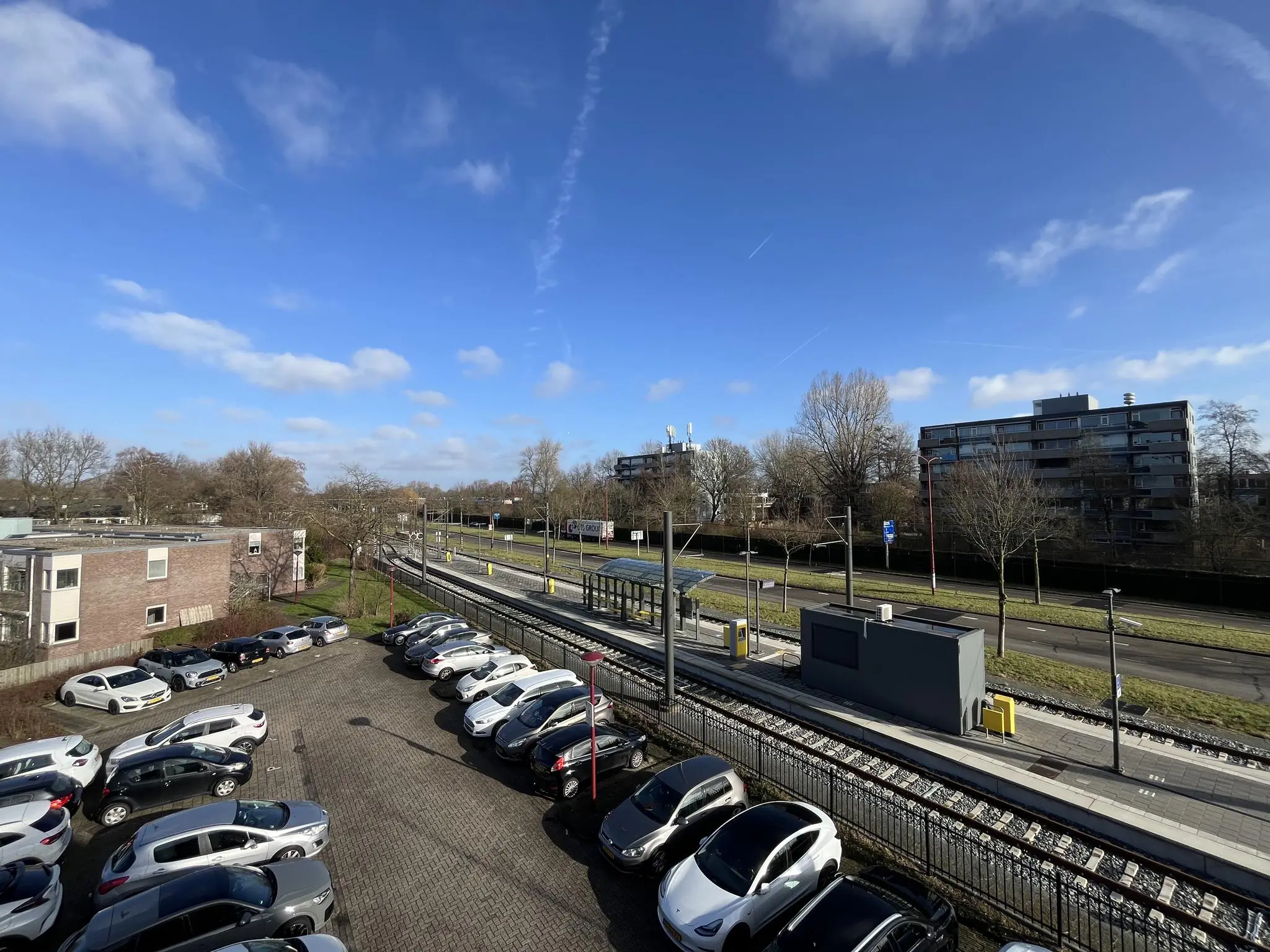 Parkeerterrein naast tramhalte Ratelaar in een woonwijk op een zonnige dag.