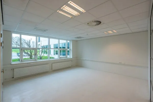 Leeg kantoorpand aan het Rhijnspoor met grote ramen en systeemplafond.