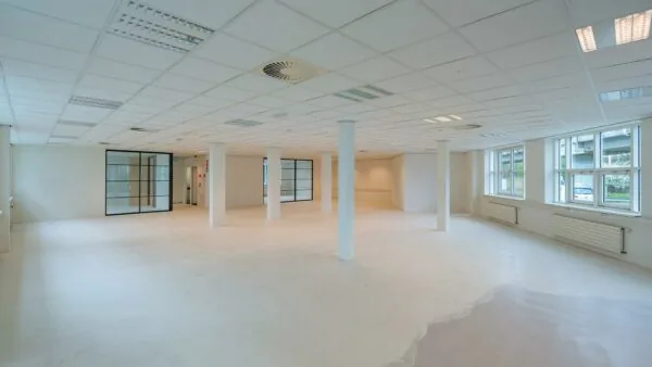 Licht en modern kantoorpand aan het Rhijnspoor met glazen wanden en grote ramen.